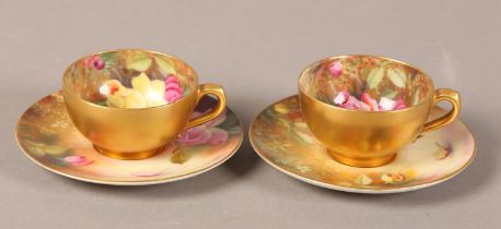 A pair of Royal Worcester cabinet cups and saucers, painted with yellow and pink roses, signed Twin,