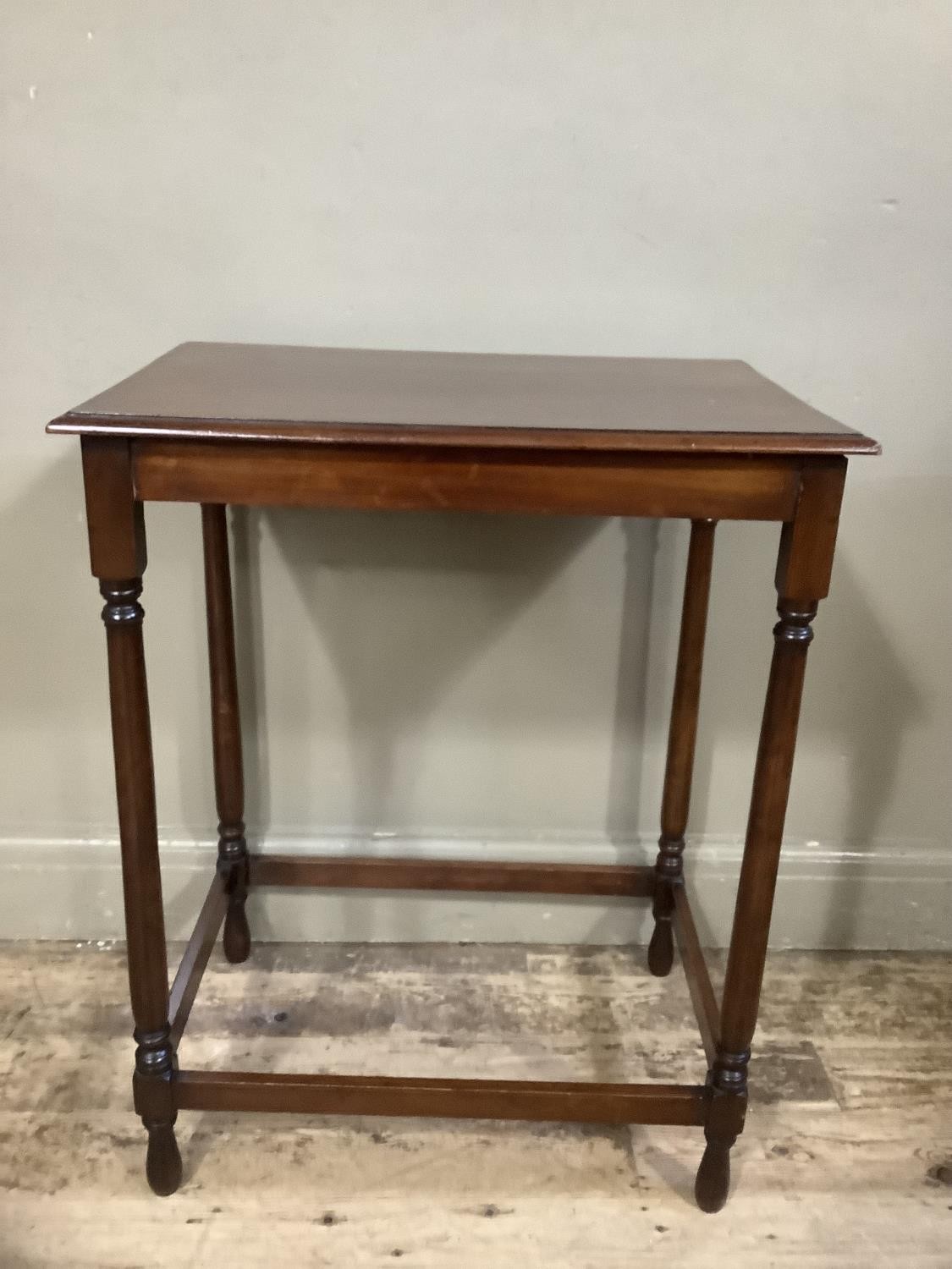 A mahogany occasional table of rectangular outline on slender turned legs joined by peripheral