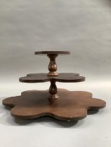 A mahogany three tier stand with revolving base