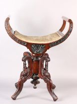 A Late 19th century mahogany revolving piano stool, the dished seat with open curved upright arms,