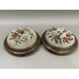 A pair of late Victorian circular footstools with needlework and beaded floral covers on bun feet