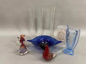 A collection of art glass comprising three slender vases, a twin handled blue vase of wrythen