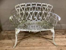 A cast iron white painted ornate pierced garden bench