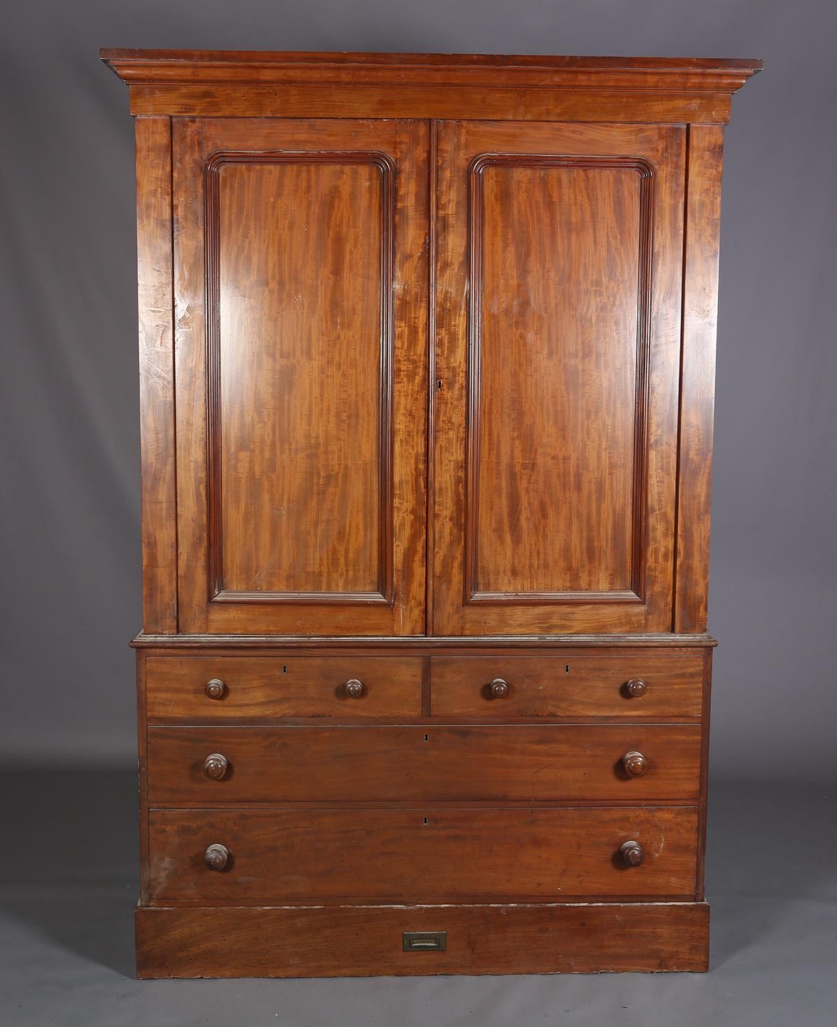 A 19th century mahogany clothes press, having a moulded cornice above two indented panel doors,