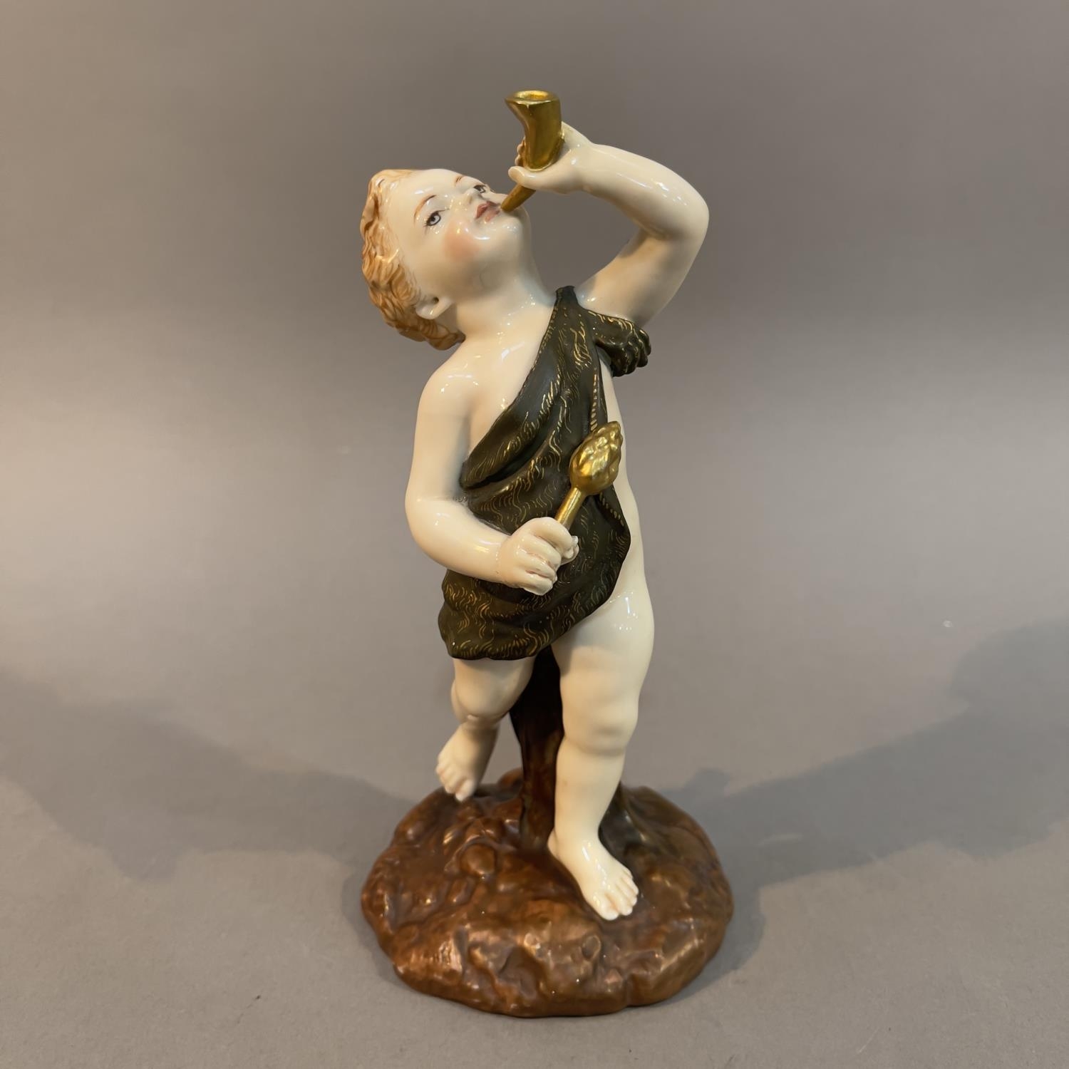 A Royal Worcester figure of a dancing cupid, holding a horn to his lips, on naturalistic base,