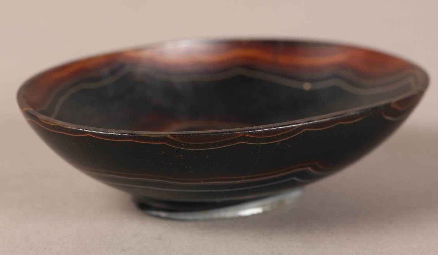 A banded agate bowl of oval outline on foot rim, 9cm wide x 6.5cm deep x 2.75cm high (two cracks - Image 2 of 4