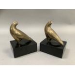 A pair of brass hawk bookends on ebonised, rectangular plinths, 13cm wide x 10cm deep x18cm high