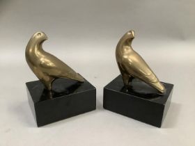 A pair of brass hawk bookends on ebonised, rectangular plinths, 13cm wide x 10cm deep x18cm high