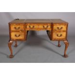 An 18th century style figured walnut desk, inverted breakfront, having three incised leather panels,