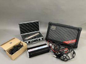 A Roland Street Cube battery powered PA amplifier, along with a cased AKG C1000S microphone and a