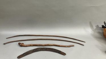 A 19th century Aboriginal boomerang and two bows, together with a Chinese root wood stick