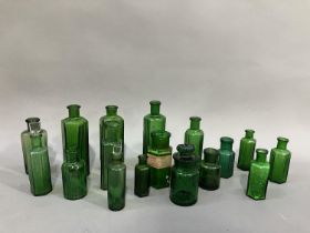 A collection of sixteen green glass poison bottles, (two with stoppers) 7cm to 13.5cm high, one with