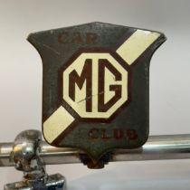 A collection of four car mascots and owners club badges, including a Desmo terrier mascot, a MG