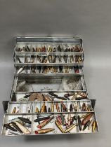 A quantity of vintage lures by Hardy's of Alnwick, Abu of Sweden and others, contained in a metal