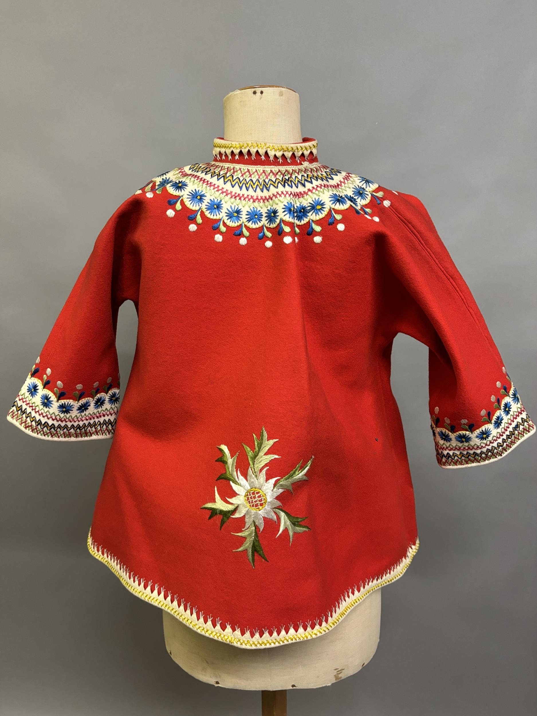 A Child’s folk dress coat, in red wool with cream cuffs, seam and collar, heavily embroidered with - Image 4 of 7