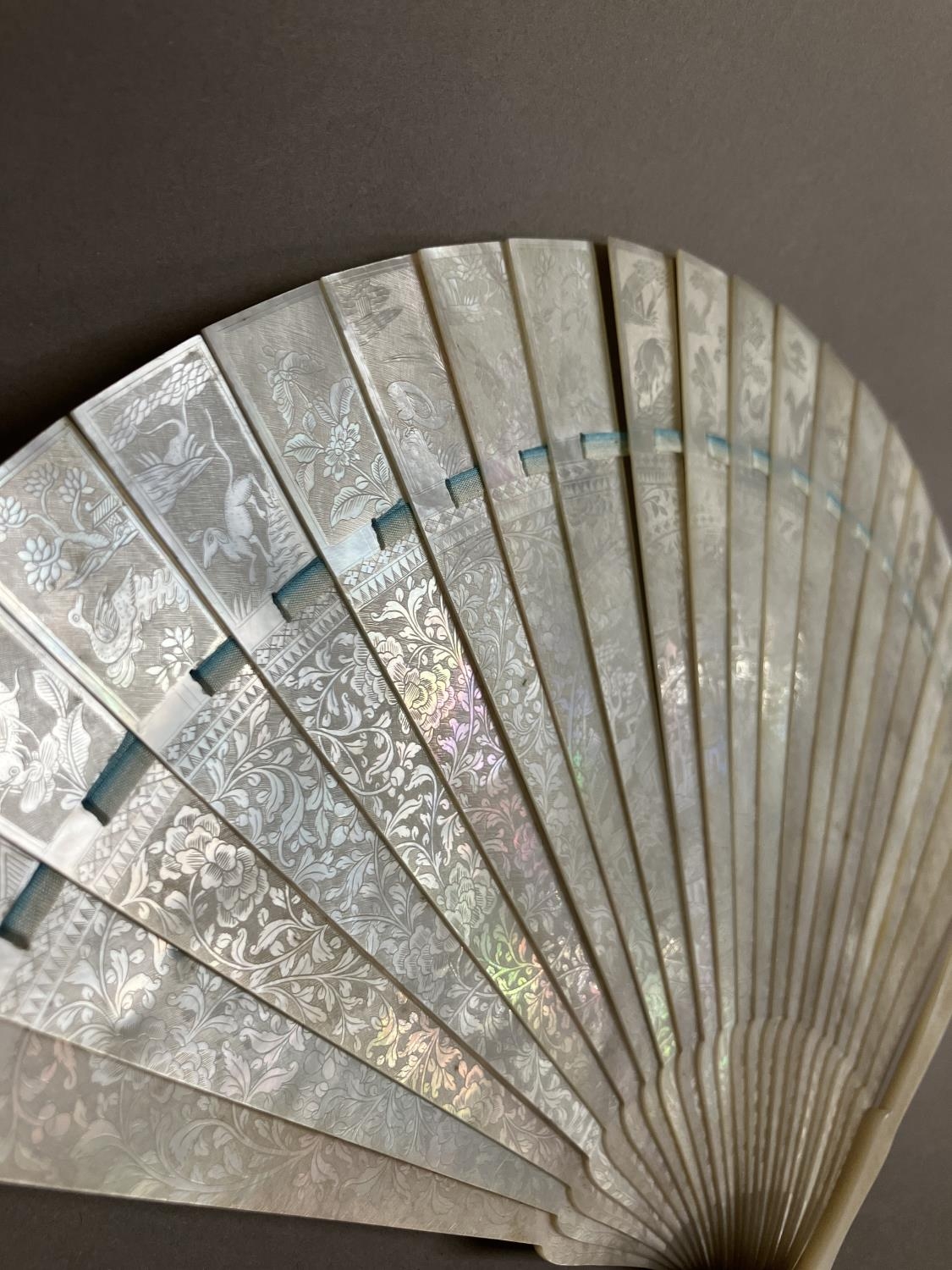 A Chinese Mother of pearl brisé fan, with 21 inner sticks and two guards, entirely etched with - Image 5 of 14