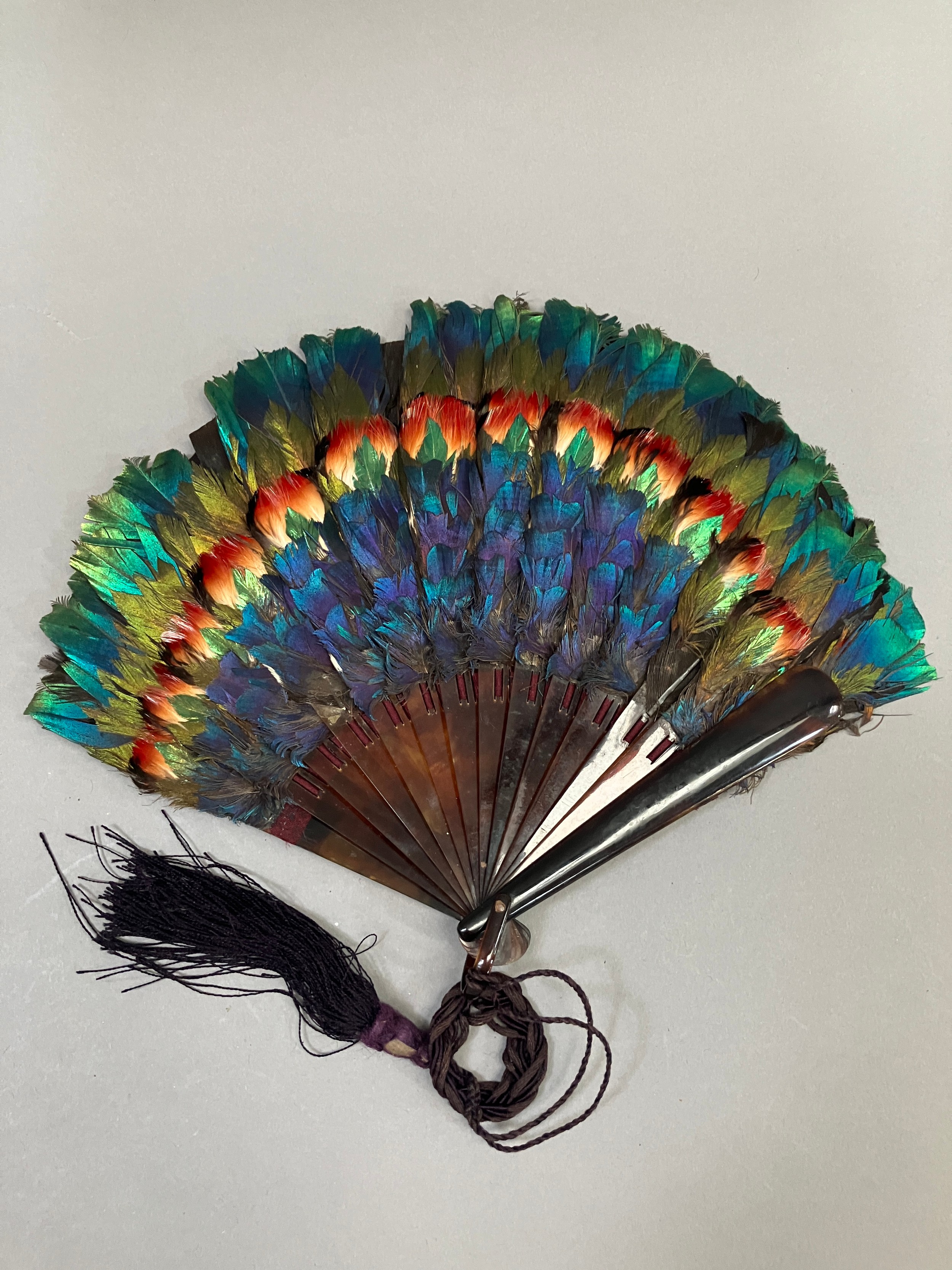 A small and attractive marquetry feather fan, the monture of faux tortoiseshell, the bands of