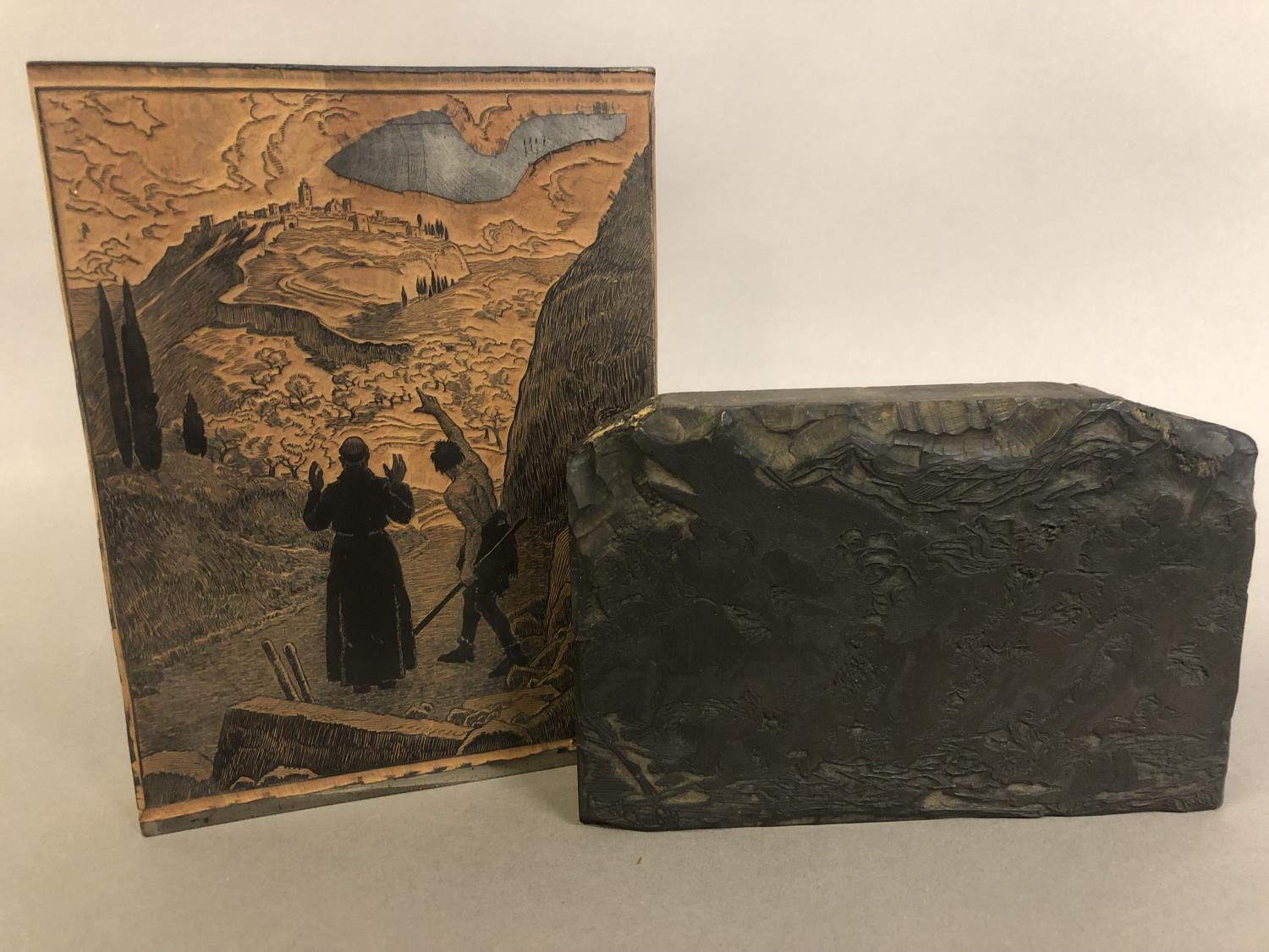 Antique French wood printing blocks, one figurative, with a monk being guided to a hilltop fortified