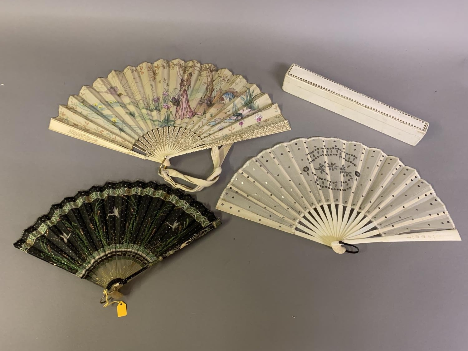 An Art Nouveau fan, the monture of bone, shaped and gilded, the silk leaf painted with a lady in a