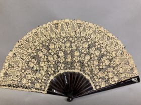 A large late 19th century Carrickmacross lace fan, worked with more detail towards the upper edge,