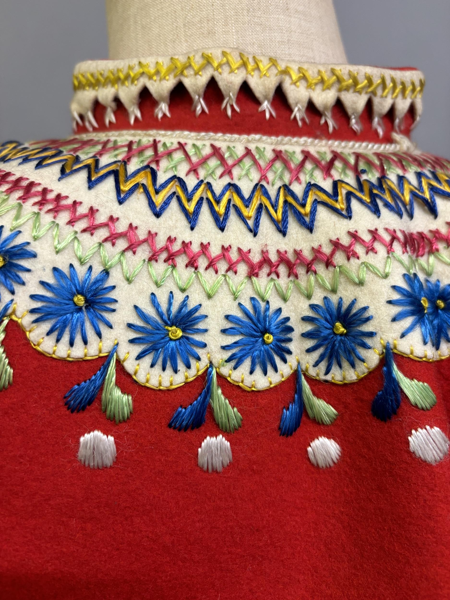 A Child’s folk dress coat, in red wool with cream cuffs, seam and collar, heavily embroidered with - Image 5 of 7