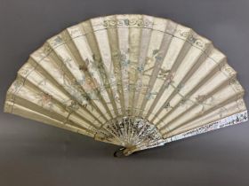 A large fan, the monture of pink mother of pearl, gilded, the cream silk leaf Chinese, being
