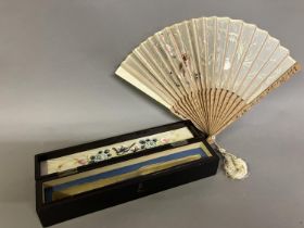A Chinese gauze fan, Ming Dynasty, the wood monture carved, the leaf embroidered in pastel silks