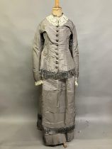 A c 1880’s two piece light grey silk ensemble, the long-line bodice tailored and shaped at the