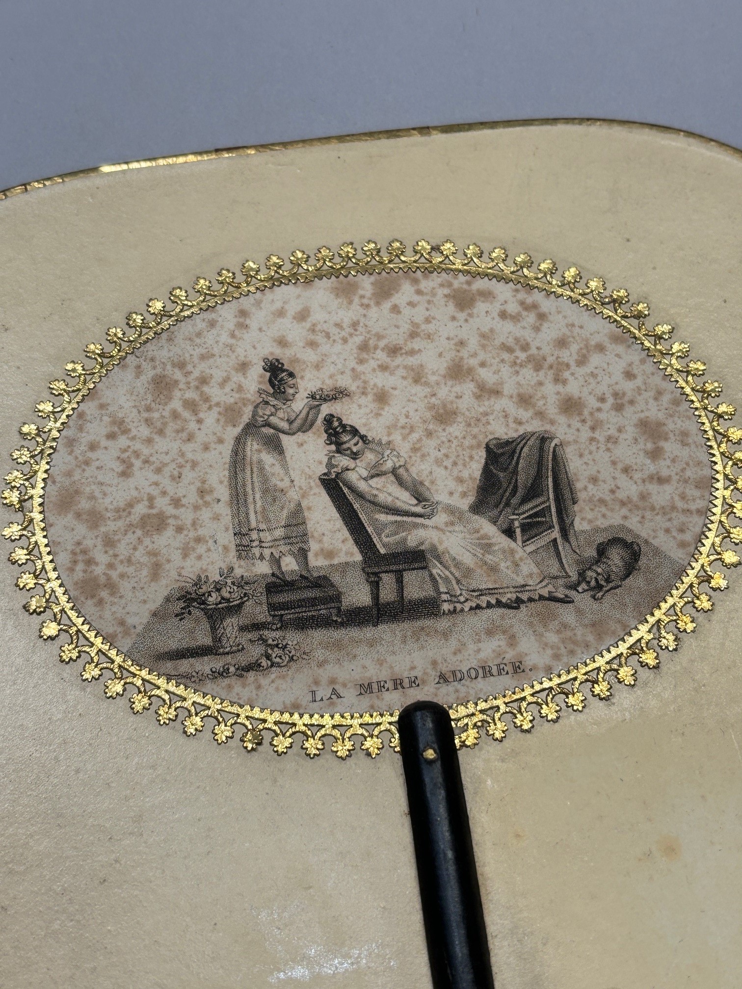 A good regency fixed fan, shaped, the recto applied with gold foil and a gravure showing a mother - Image 3 of 3