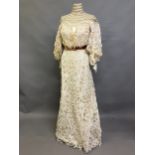 An Edwardian tapelace wedding ensemble, the high-necked bodice in ivory silk satin, trimmed with