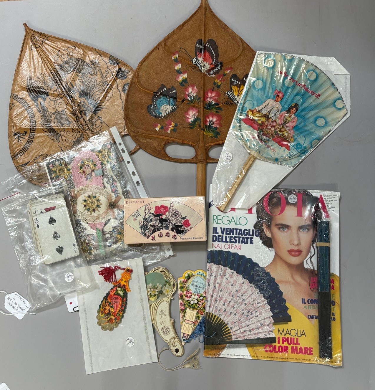 A selection of fans and ephemera: a 19th century greetings card, cut paper, silvered , applied