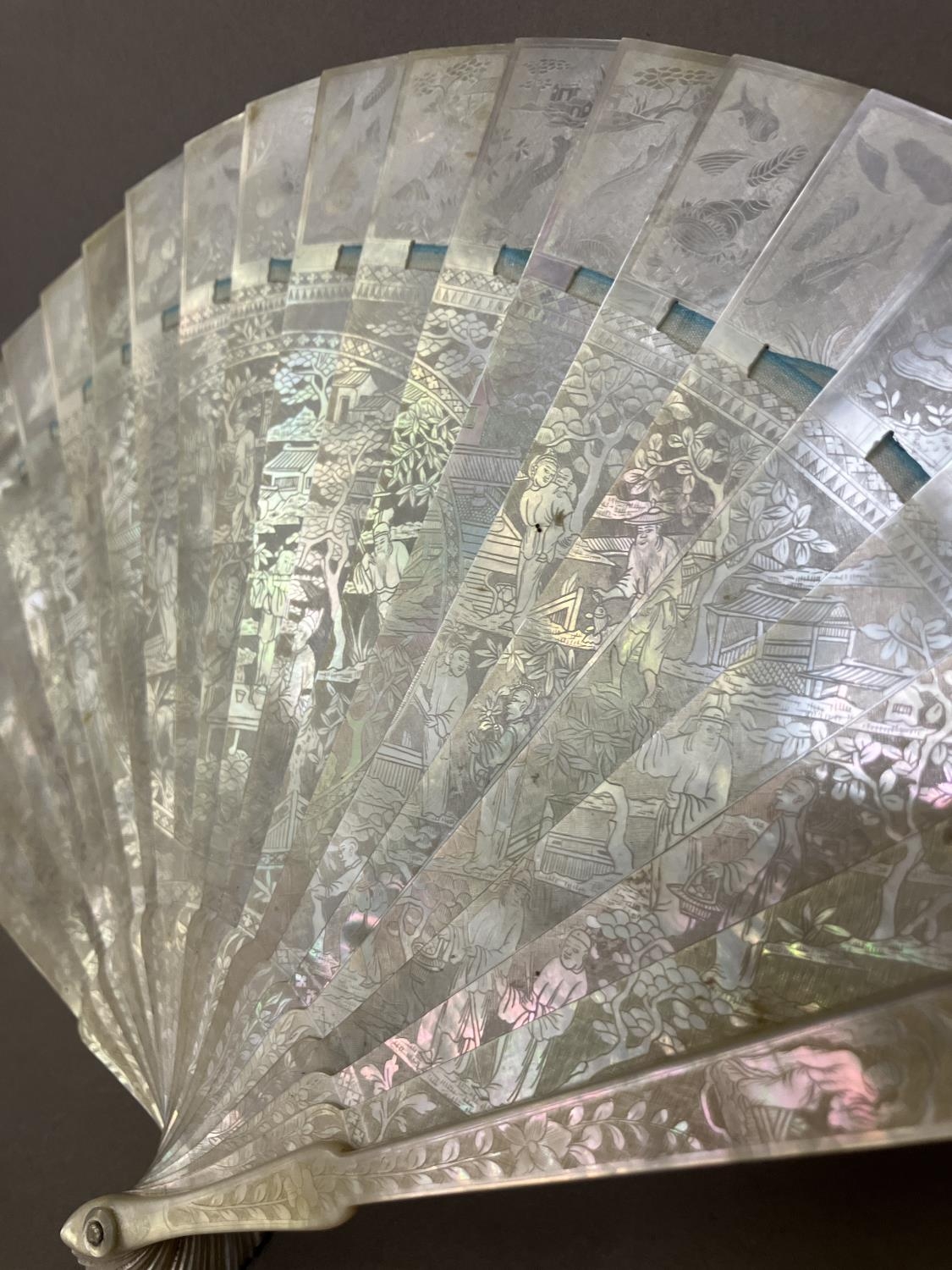 A Chinese Mother of pearl brisé fan, with 21 inner sticks and two guards, entirely etched with - Bild 13 aus 14