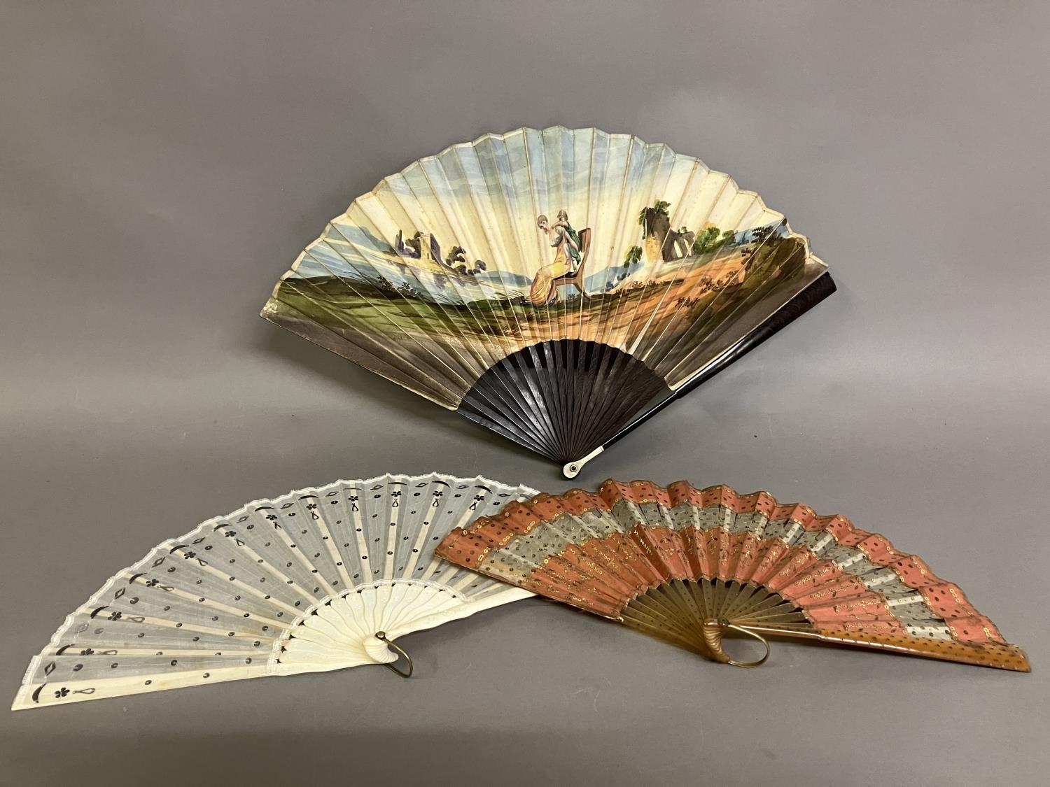 A Regency engraved and coloured fan with double paper leaf, and slender wood monture with bone thumb