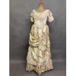 An elaborate 1880’s wedding or evening gown, skirt with integral boned bodice, a heavy honey silk,