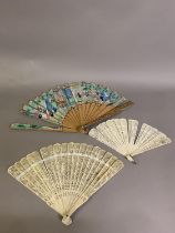 A Chinese Qing Dynasty asymmetrical carved wood Mandarin fan, 19th century, the leaf with robed