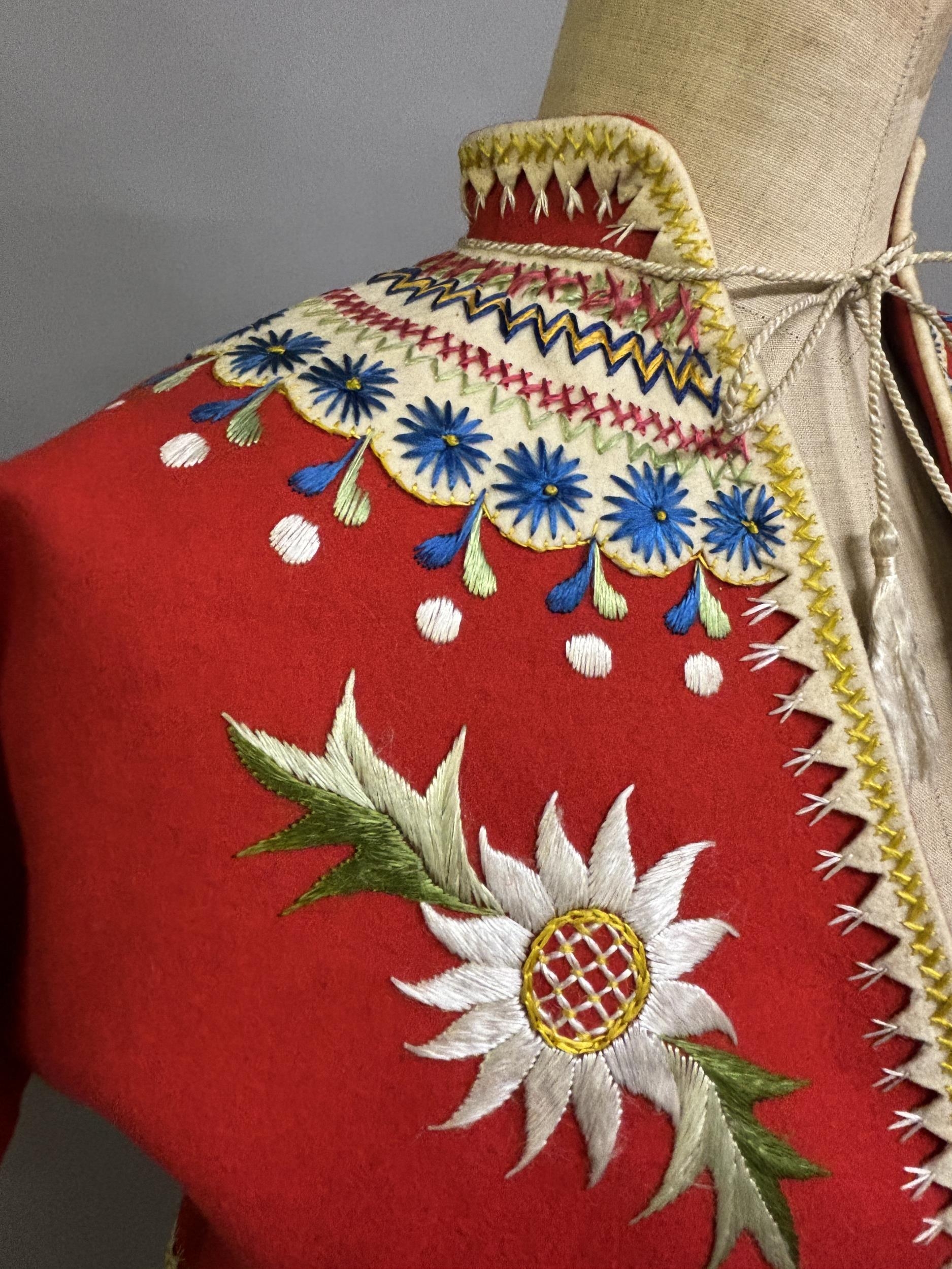 A Child’s folk dress coat, in red wool with cream cuffs, seam and collar, heavily embroidered with - Image 2 of 7