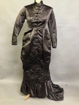 A chestnut brown silk two-piece costume, c 1880’s, the tailored long-line jacket with covered