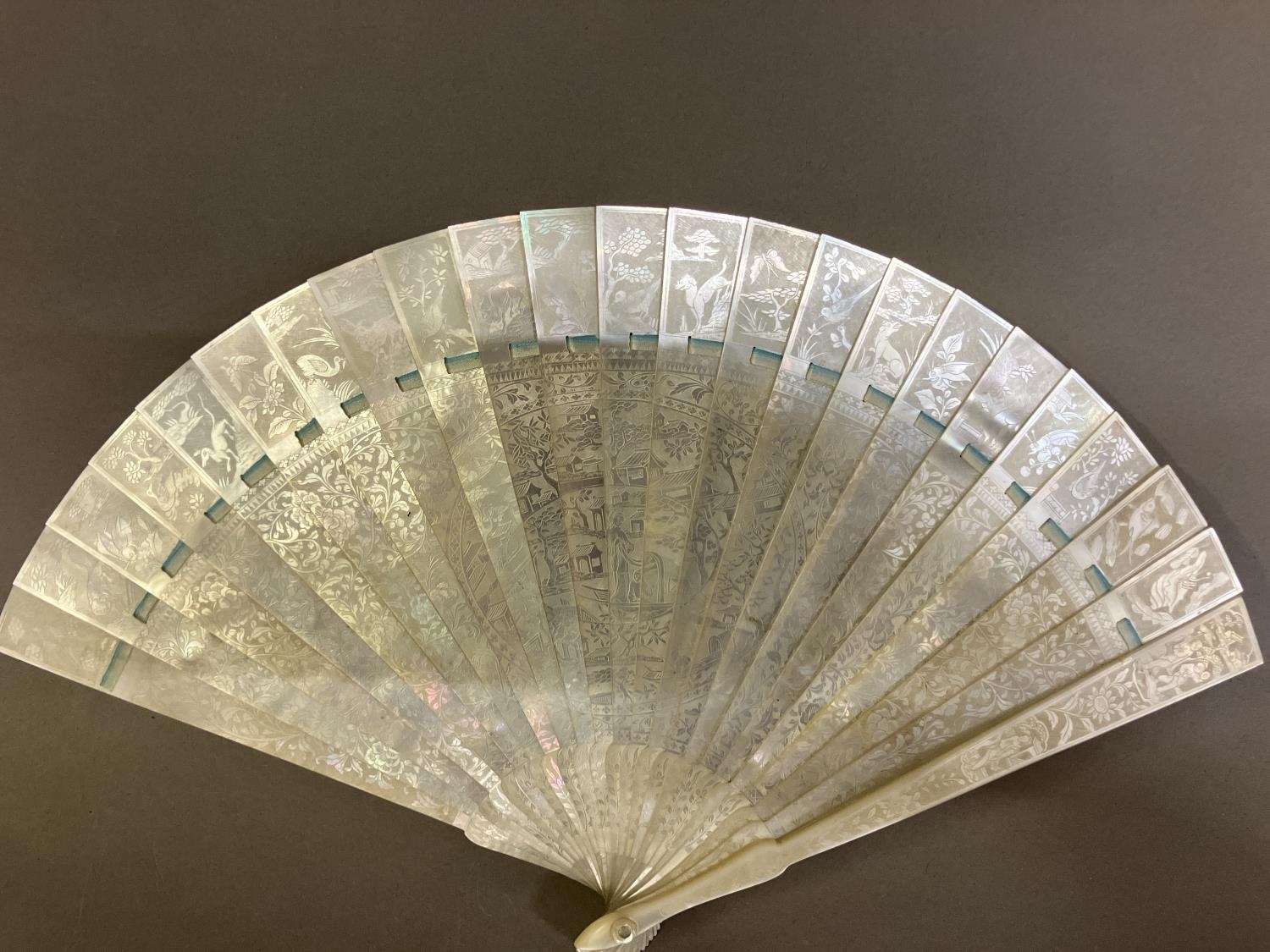 A Chinese Mother of pearl brisé fan, with 21 inner sticks and two guards, entirely etched with - Image 2 of 14