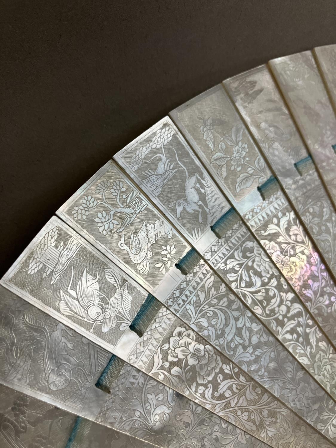 A Chinese Mother of pearl brisé fan, with 21 inner sticks and two guards, entirely etched with - Bild 7 aus 14