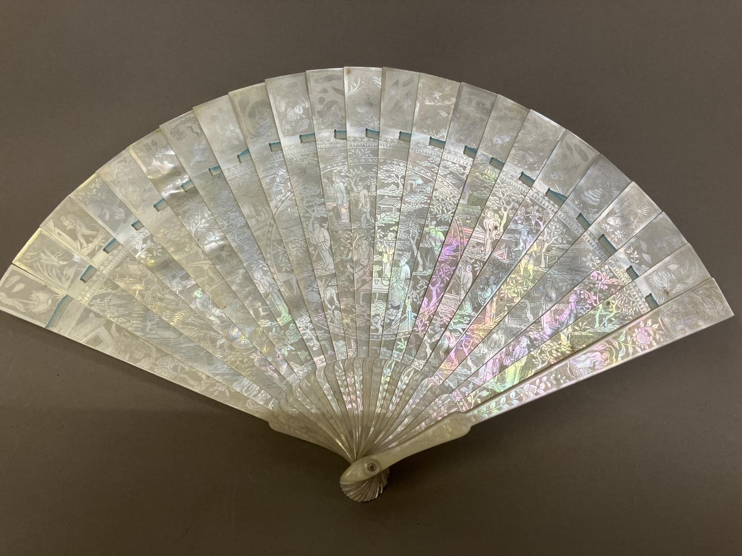 A Chinese Mother of pearl brisé fan, with 21 inner sticks and two guards, entirely etched with - Image 12 of 14