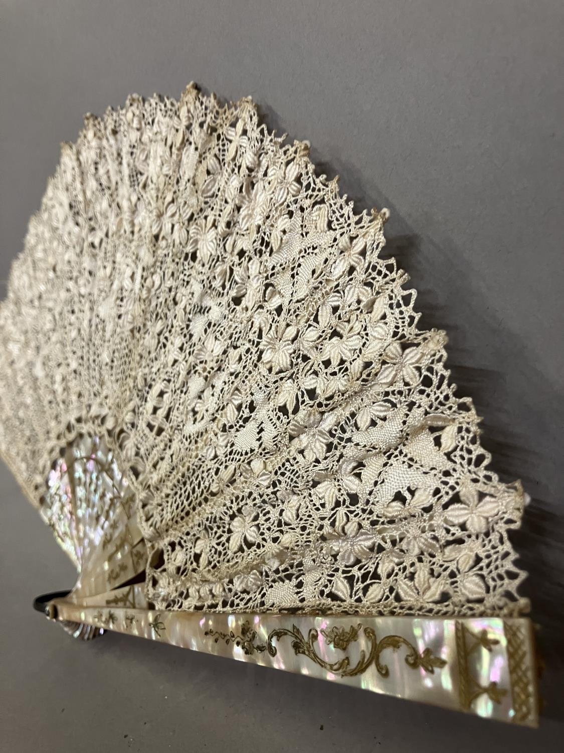 Antique Lace: an early 20th century Maltese silk lace fan, the leaf mounted on pink mother of - Image 2 of 6