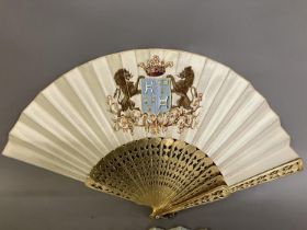 Two mid-19th century fans, the first with carved and pierced wood sticks, painted in gold, the cream