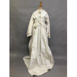A mid-1860’s two-piece wedding ensemble, cream silk, the tailored bodice with bell sleeves, the