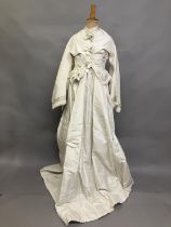 A mid-1860’s two-piece wedding ensemble, cream silk, the tailored bodice with bell sleeves, the