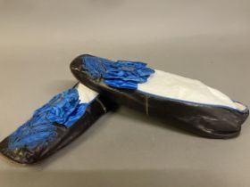 A fine pair of French mid-19th century slippers, black glacé kid, edged with blue braid, square