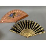 A wood fan, the monture carved and pierced, painted gold, c 1870’s, the black silk satin leaf with