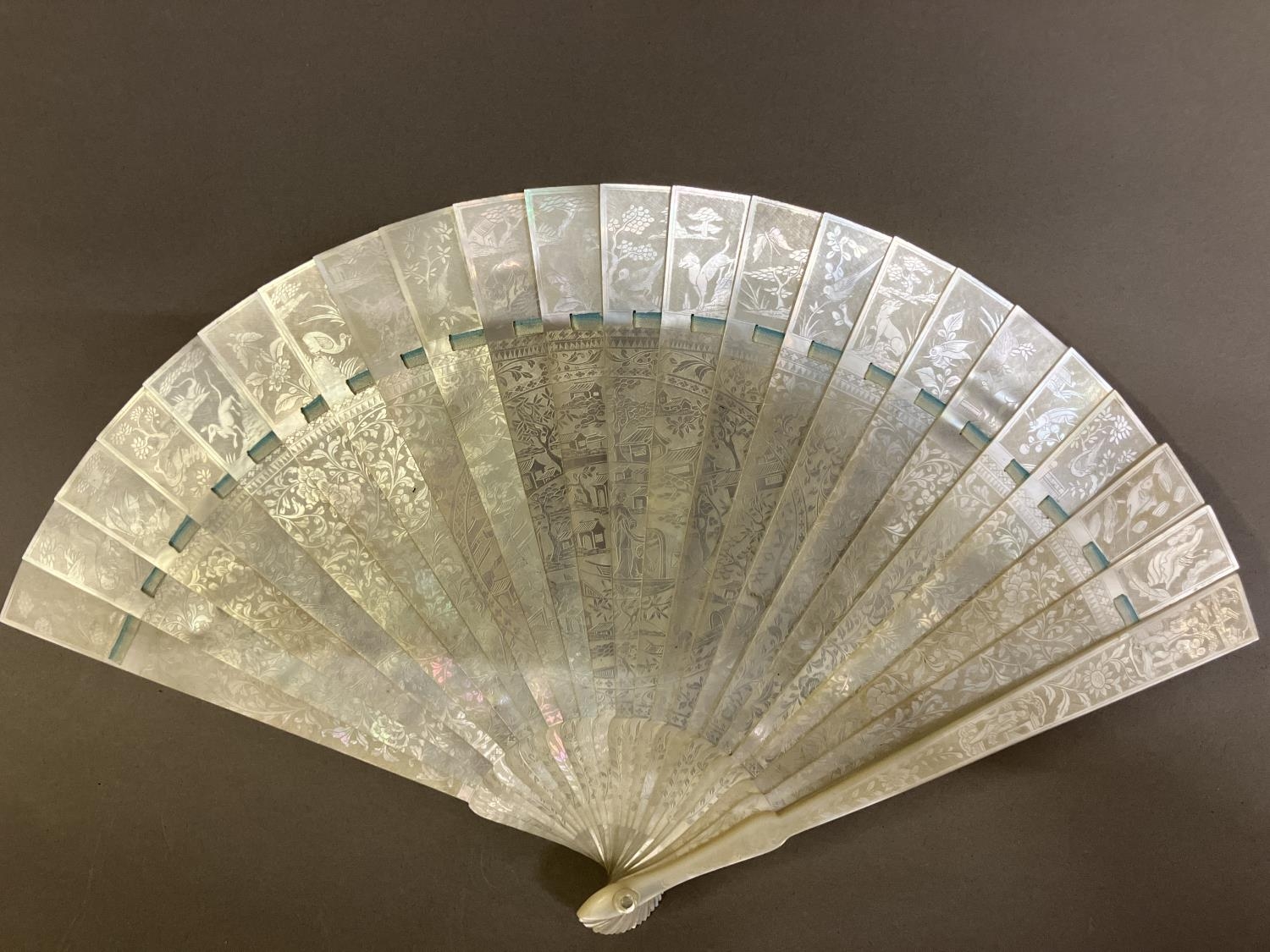A Chinese Mother of pearl brisé fan, with 21 inner sticks and two guards, entirely etched with - Image 3 of 14