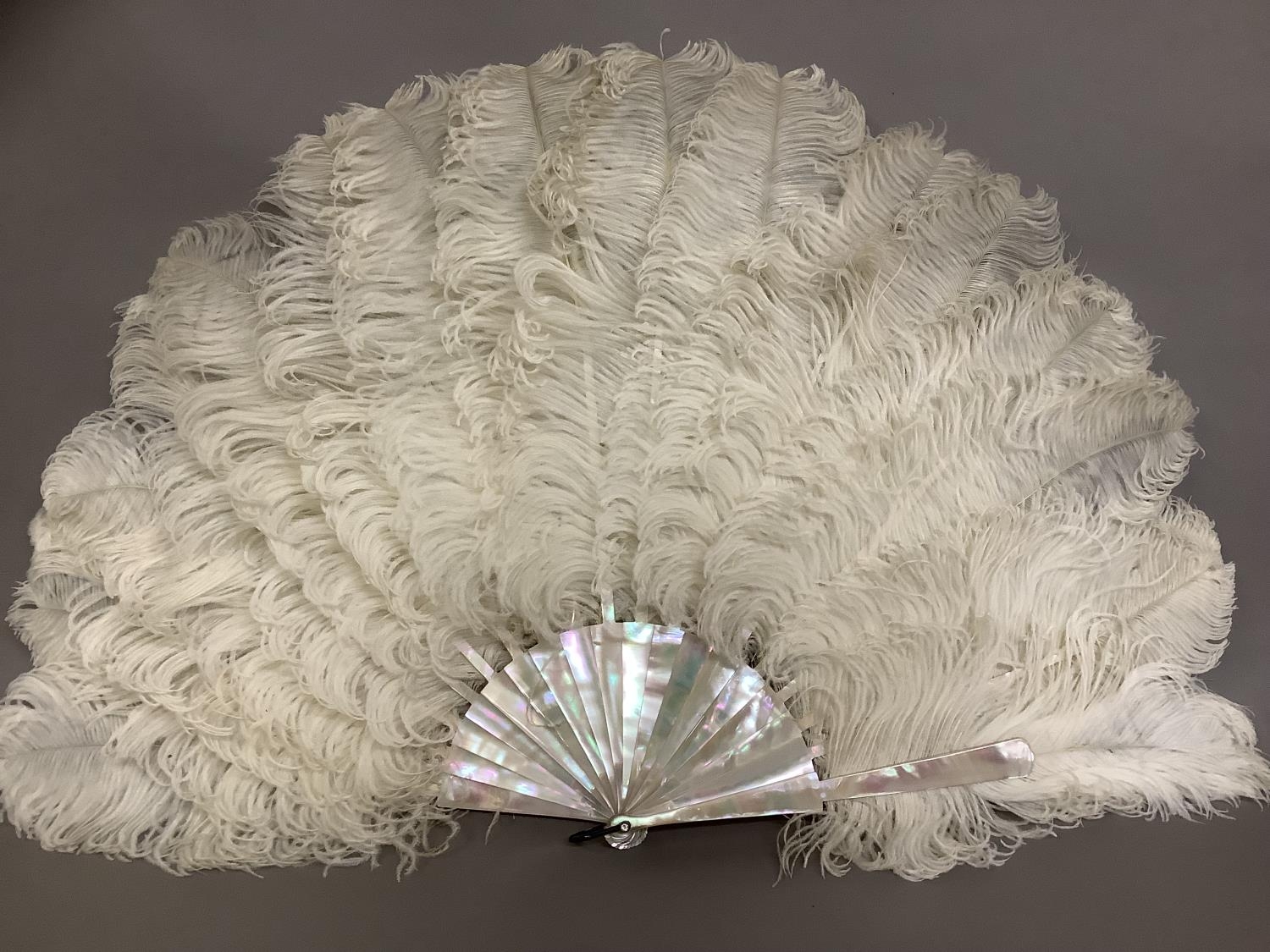 A late 19th century white ostrich feather fan, the monture of pink/green burgau mother of pearl, - Image 5 of 6