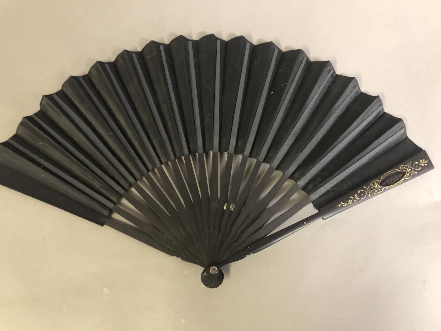 A black wood fan, carved and gilded, early 20th c, mounted with a silk leaf, painted with a courting - Image 4 of 4