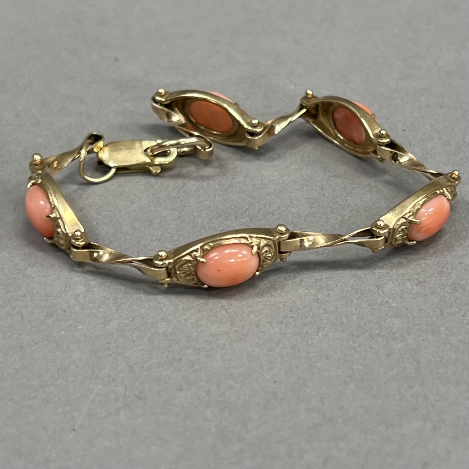 A coral bracelet in 9ct gold, each foliate patterned tonneau link claw set with an oval cabochon - Image 2 of 2